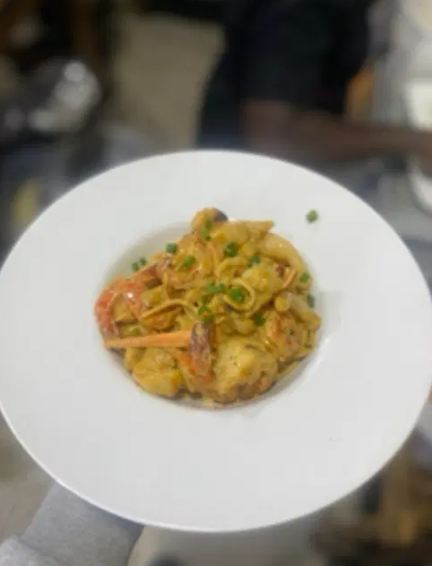 a dish of pasta in a creamy sauce with calamari and prawns